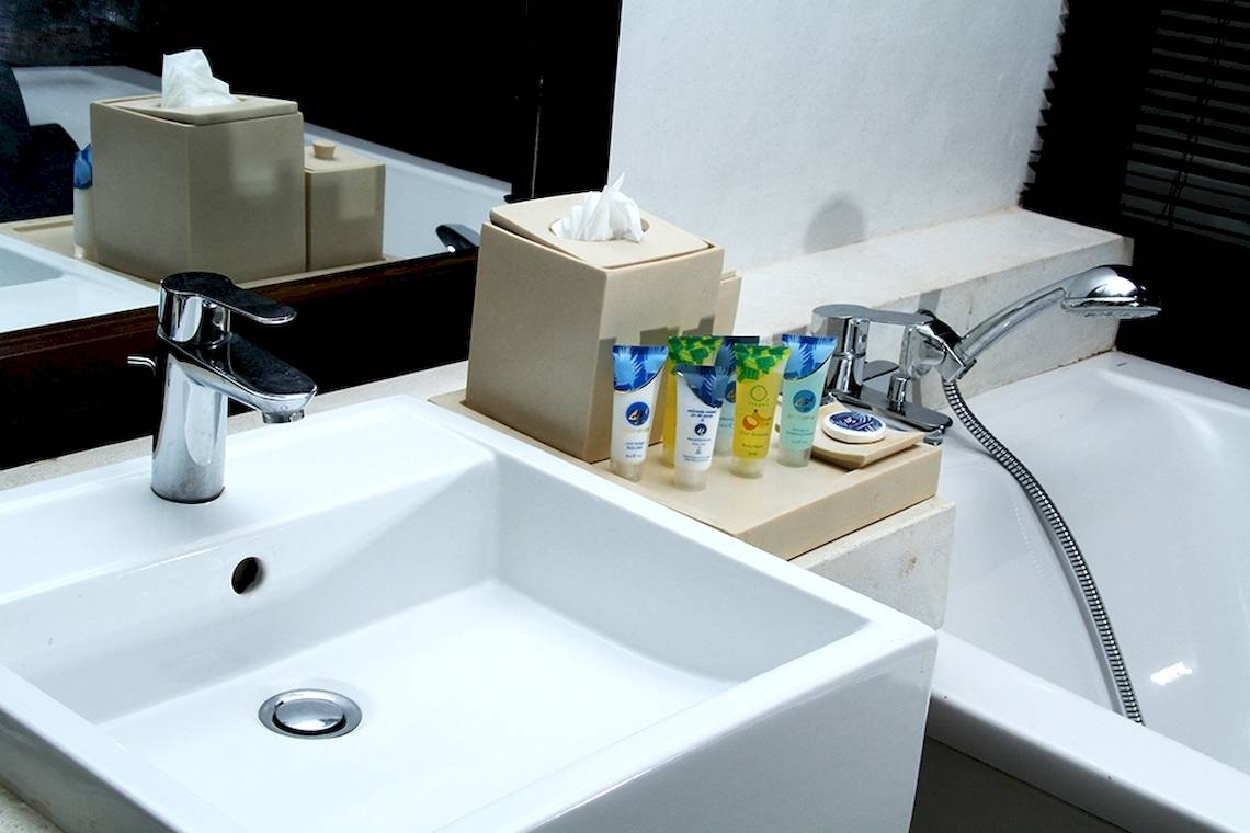 Badezimmer im Goldi Sands Hotel mit Waschbecken und Badewanne.