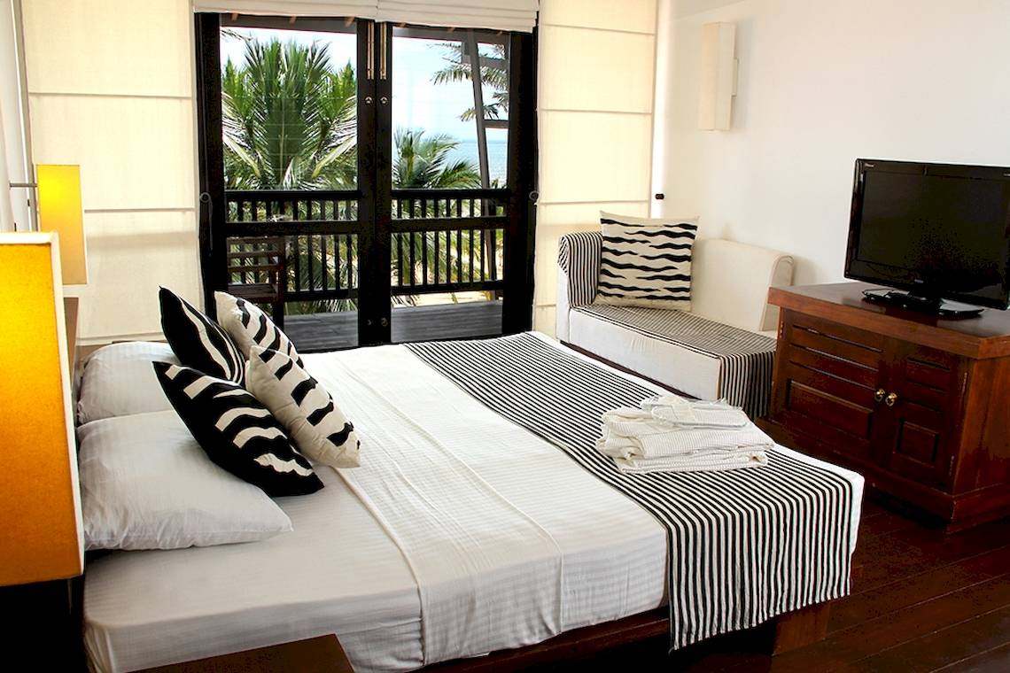 Schlafzimmer im Goldi Sands Hotel mit Blick auf den Balkon und das Meer.