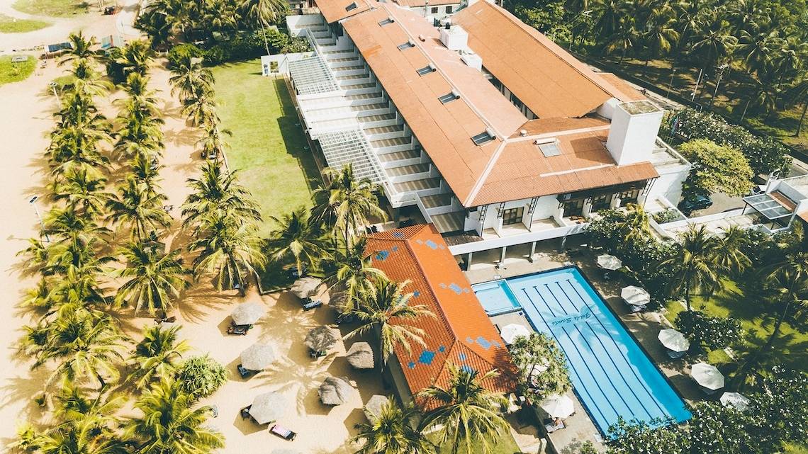 Luftaufnahme des Goldi Sands Hotels mit Swimmingpool und Palmen am Strand