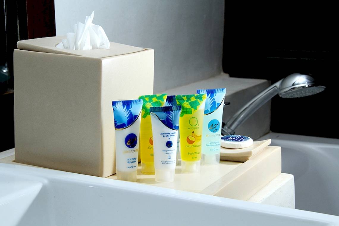 Badzubehör im Goldi Sands Hotel, bestehend aus Zahnbürstenhalter, Zahnbürsten und Shampooflaschen.