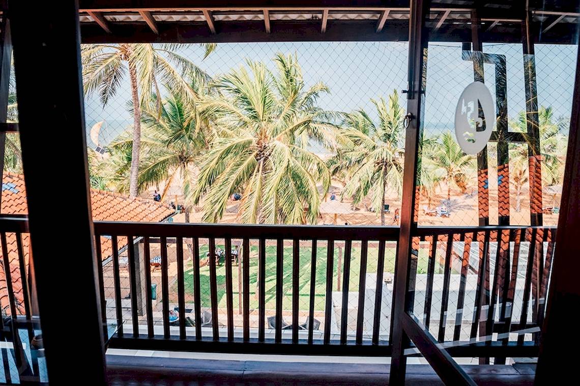 Aussicht vom Balkon des Goldi Sands Hotels auf den Strand mit Palmen und Meer.