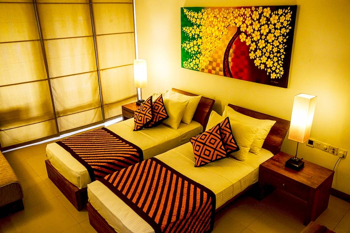 Doppelbett-Zimmer im Goldi Sands Hotel mit zwei Betten, Kissen und Lampen.