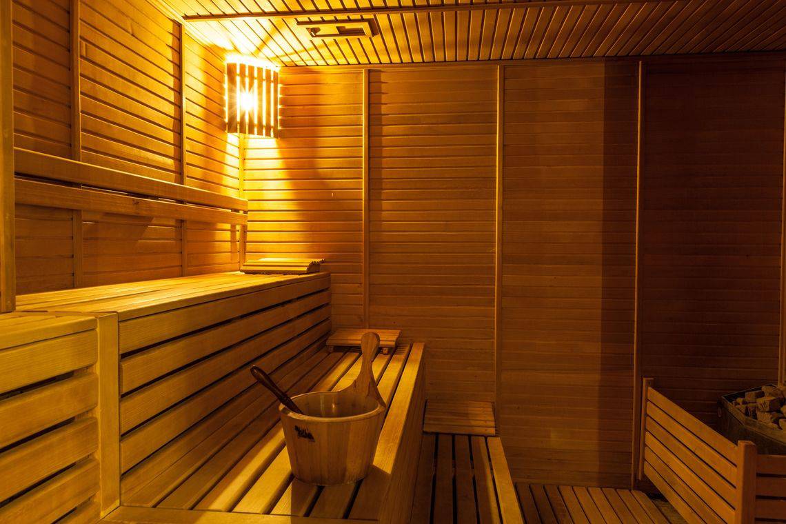 Sauna im Adalya Bliss Hotel mit Holzbänken und einem Eimer auf der Bank
