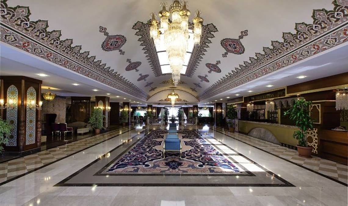 Empfangshalle des Adalya Bliss Hotels mit Kristallleuchter und Teppich