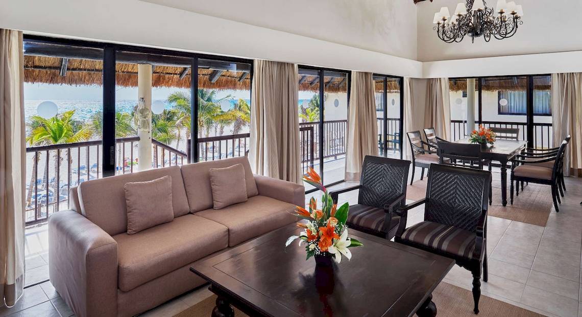 Wohnbereich des Allegro Playacar Hotels mit Blick auf das Meer und Palmen.