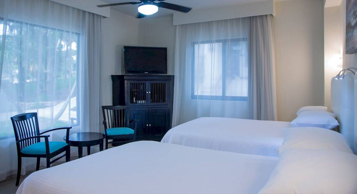 Hotelzimmer im Allegro Playacar mit zwei Betten, einem Fernseher und Möbeln.