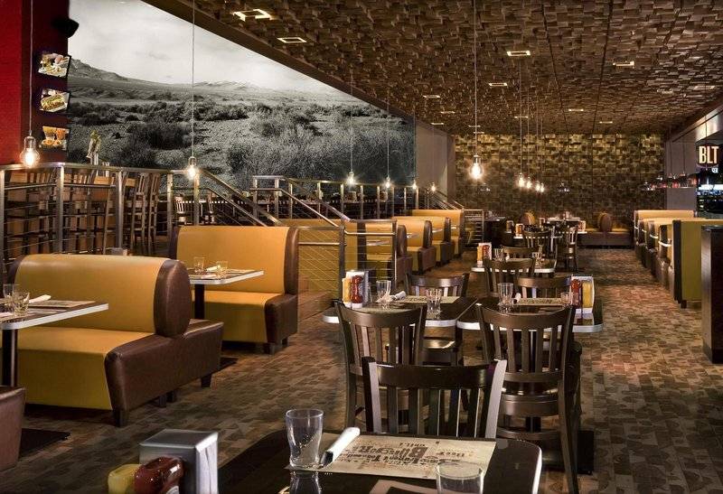 Innenbereich des Speiserestaurants im Mirage Hotel & Casino mit gelben Ledersitzen und einer großen Wandmalerei.
