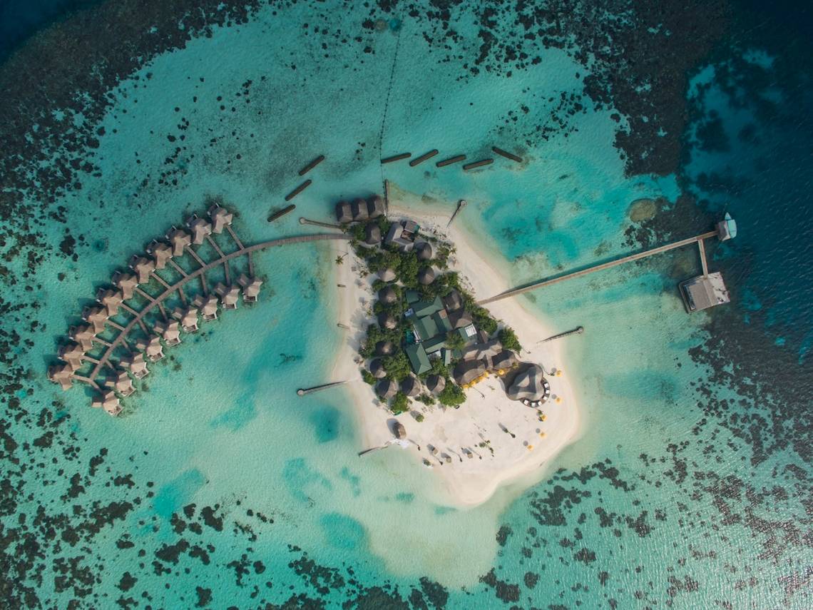 Luftaufnahme von Drift Thelu Veliga Retreat Insel mit Wasserbungalows und Steg