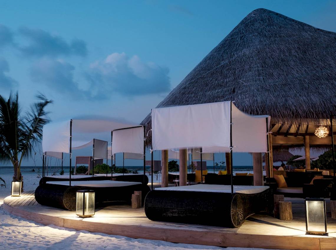 Außenbereich des Drift Thelu Veliga Retreat mit Strandbetten und Überdachungen