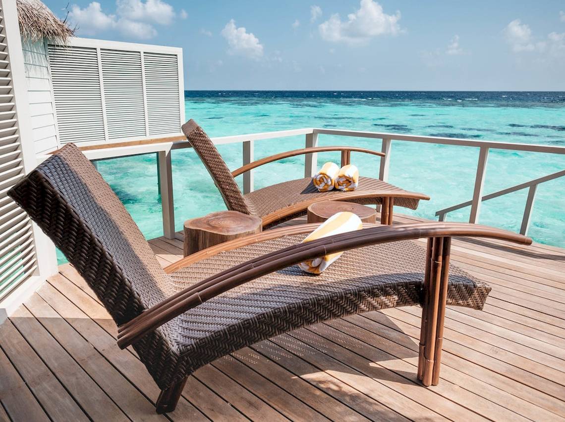 Terrasse des Drift Thelu Veliga Retreat mit Sonnenliegen und Blick auf das Meer.