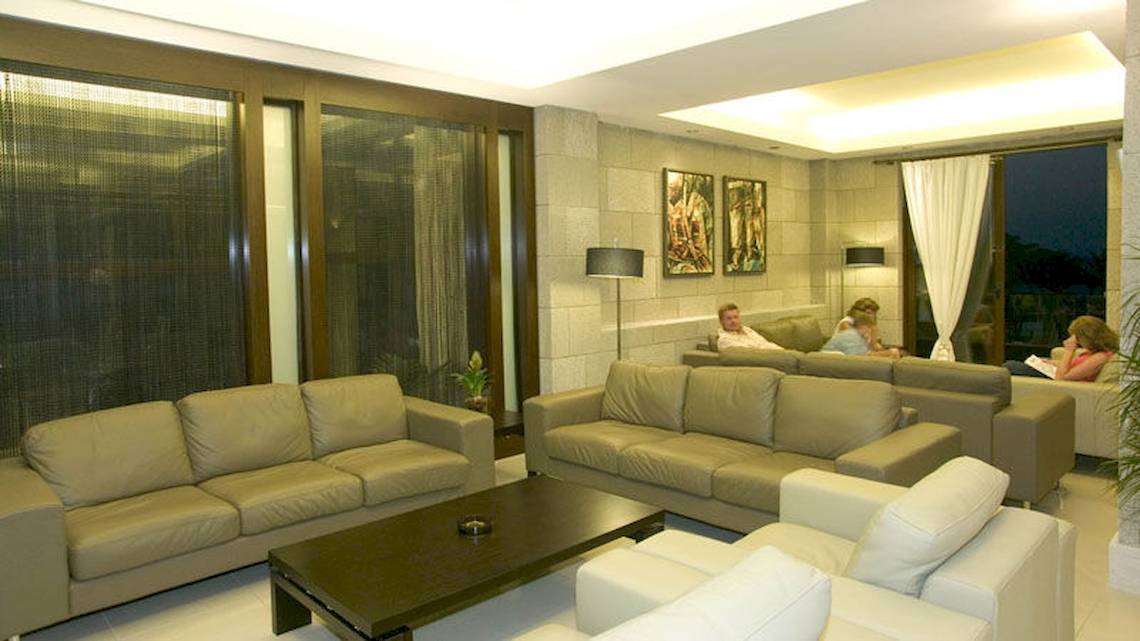 Loungebereich im D'Andrea Mare Beach Hotel mit mehreren Personen, die auf Sofas sitzen.