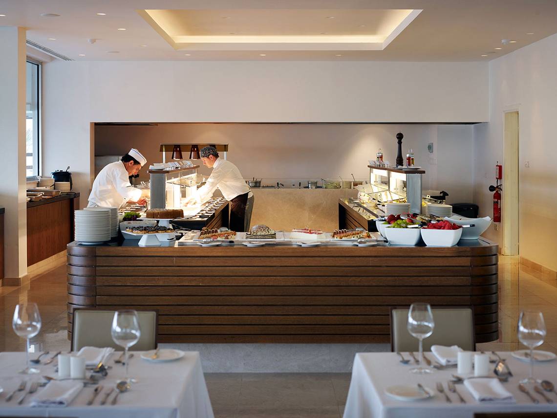 Buffettisch im Sunrise Pearl Hotel & Spa mit zwei Köchen, die Speisen zubereiten.