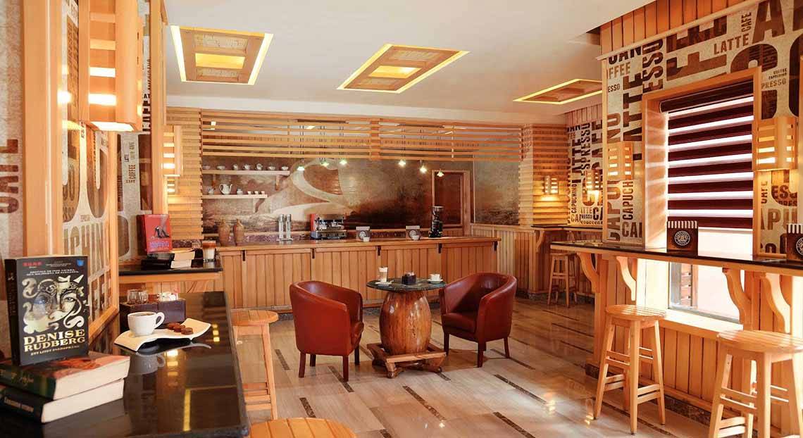 Innenansicht der Bar im Pickalbatros Alf Leila Wa Leila Resort mit Holzmöbeln, einer Theke und einer gemütlichen Sitzecke.