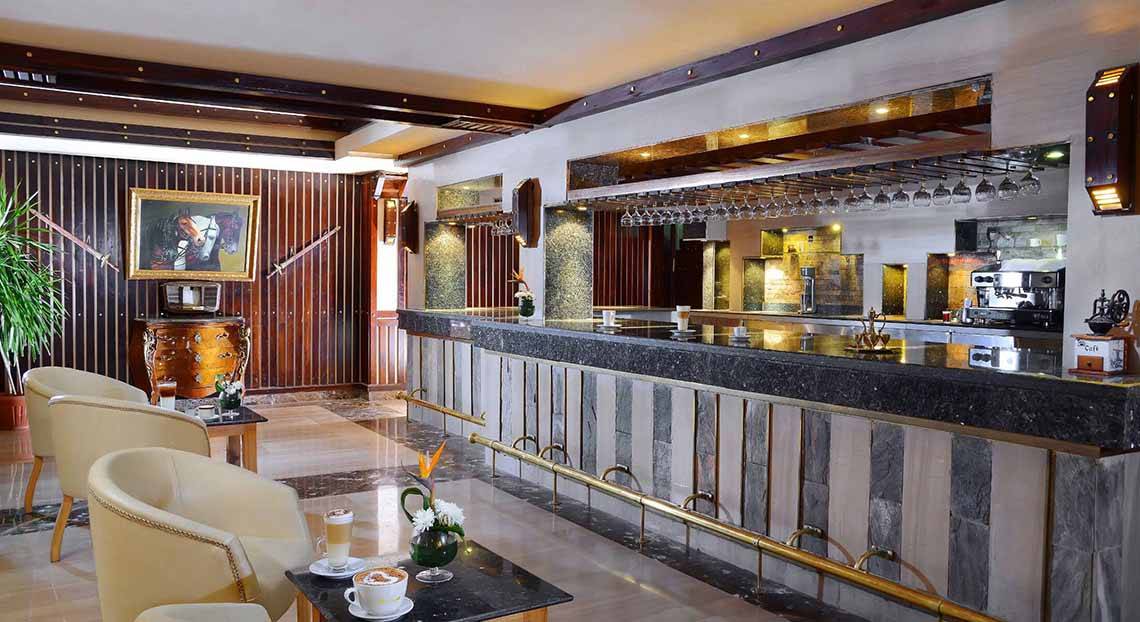 Innenansicht der Bar im Pickalbatros Alf Leila Wa Leila Resort mit einer Theke, Stühlen und Dekorationen.