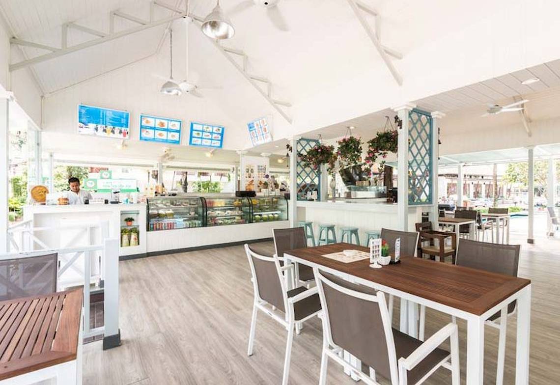 Innenansicht des Cafés im Katathani Phuket Beach Resort mit Tischen, Stühlen und Dekor.