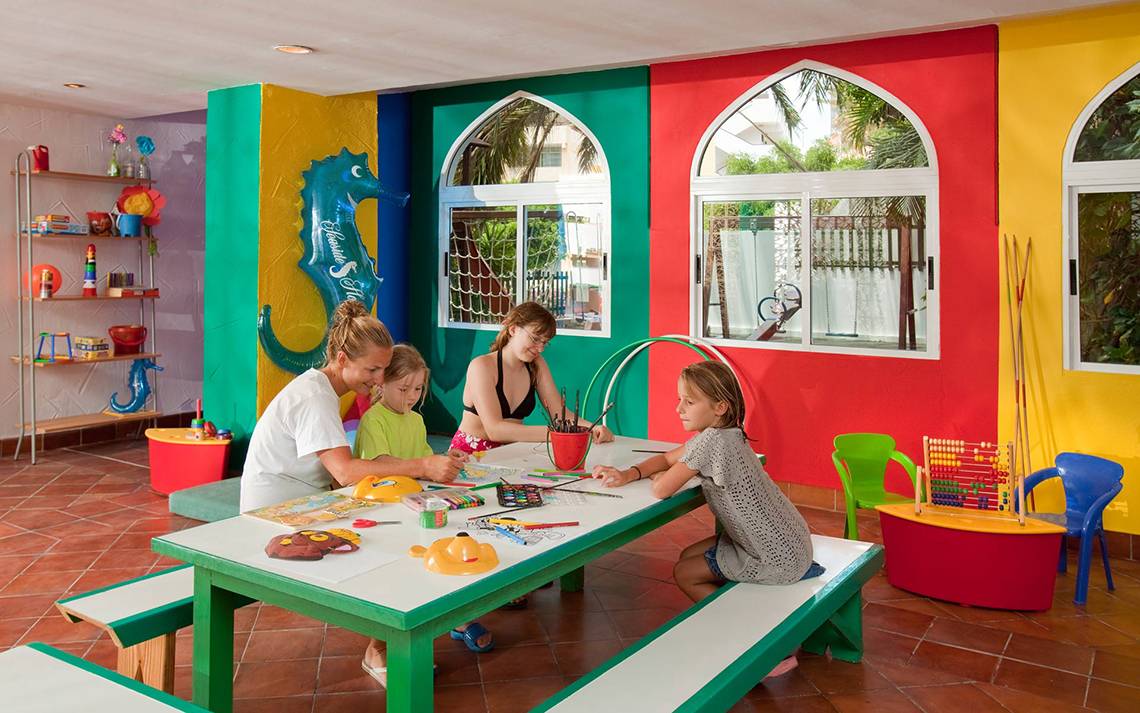 Ein buntes Kinderzimmer im Seaside Sandy Beach Hotel mit Erwachsenen und Kindern, die malen.