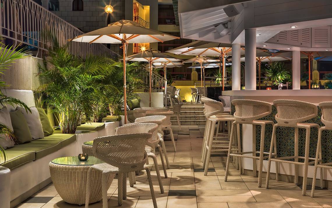 Terrasse des Seaside Sandy Beach Hotels mit Stühlen, Tischen und Schirmen bei Nacht