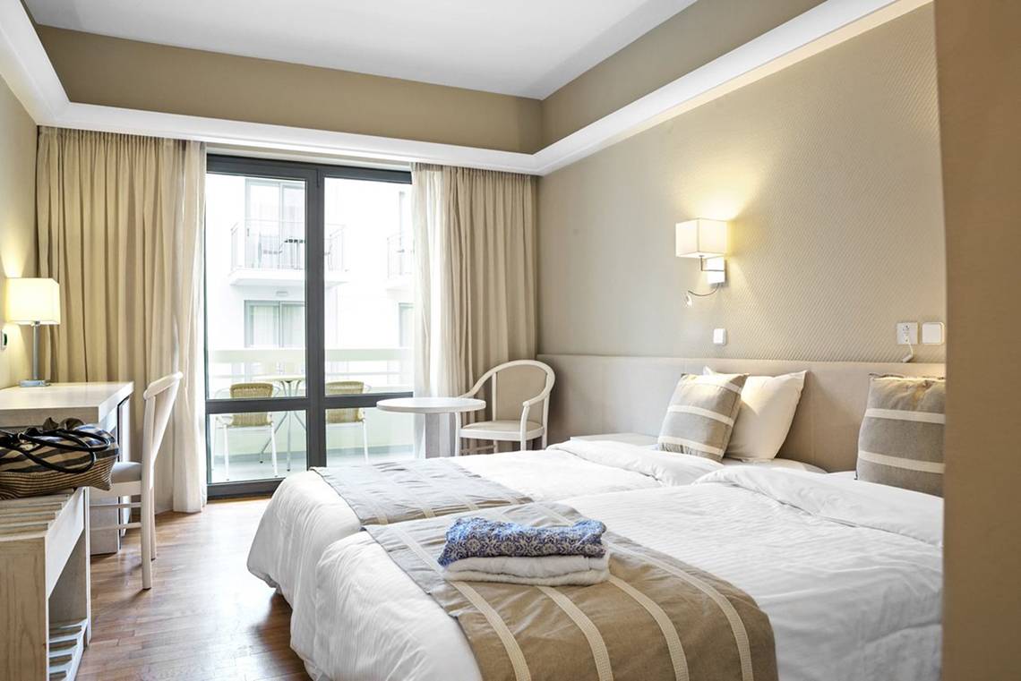 Doppelzimmer im Pearle Beach Resort & Spa mit zwei Betten und Balkon.
