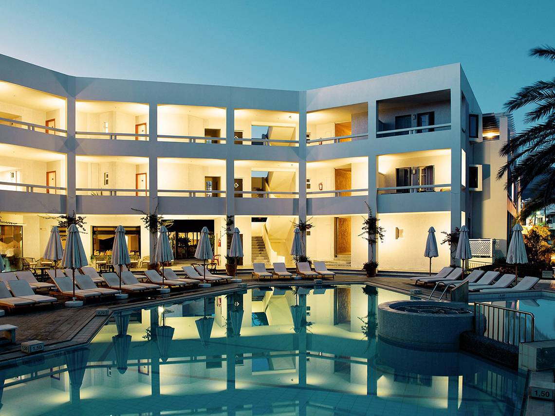 Außenansicht des Pearle Beach Resort & Spa mit illuminierten Zimmern und Swimmingpool bei Nacht