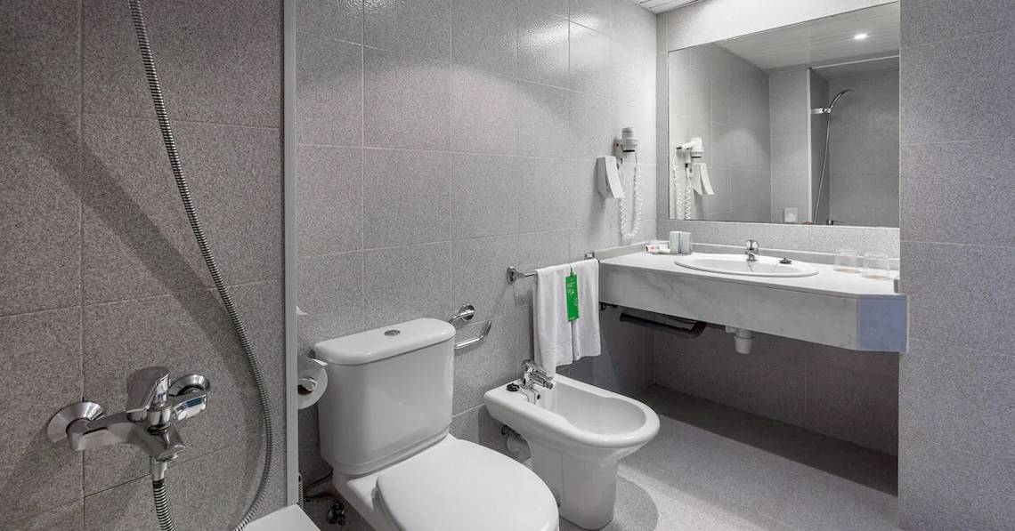 Ein Badezimmer im Sol Tenerife Hotel mit einer Dusche, Toilette, Bidet und Waschbecken.