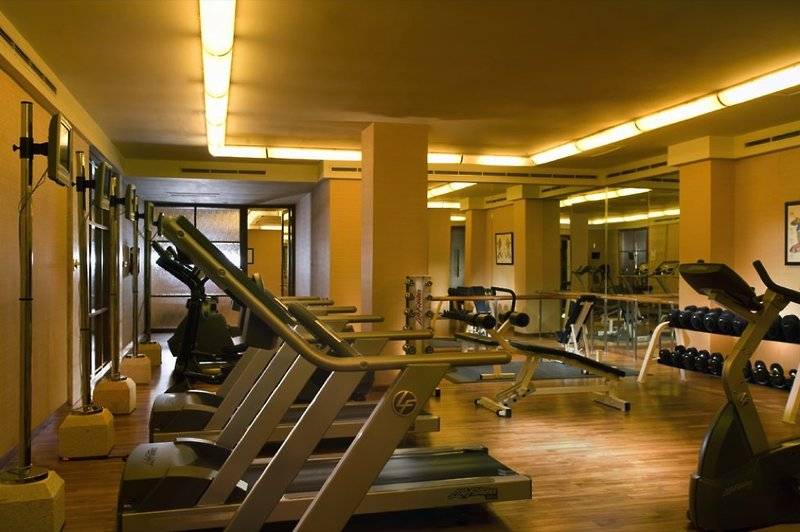 Fitnesscenter im Conrad Bali Resort & Spa mit Laufbändern, Hanteln und Spiegeln.