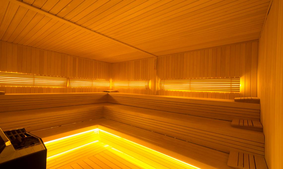 Sauna im Washington Resort Hotel & SPA mit warmem, gelbem Licht und Holzwänden.