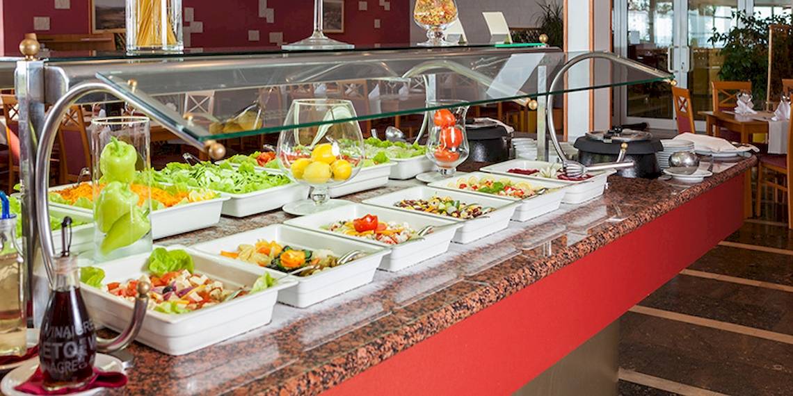 Buffet im Zora Hotel mit verschiedenen Salaten und Beilagen in weißen Schalen.