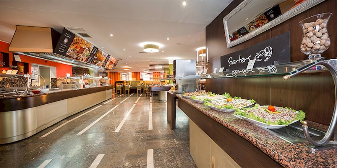 Buffetbereich im Zora Hotel mit verschiedenen Gerichten auf Marmortheke.