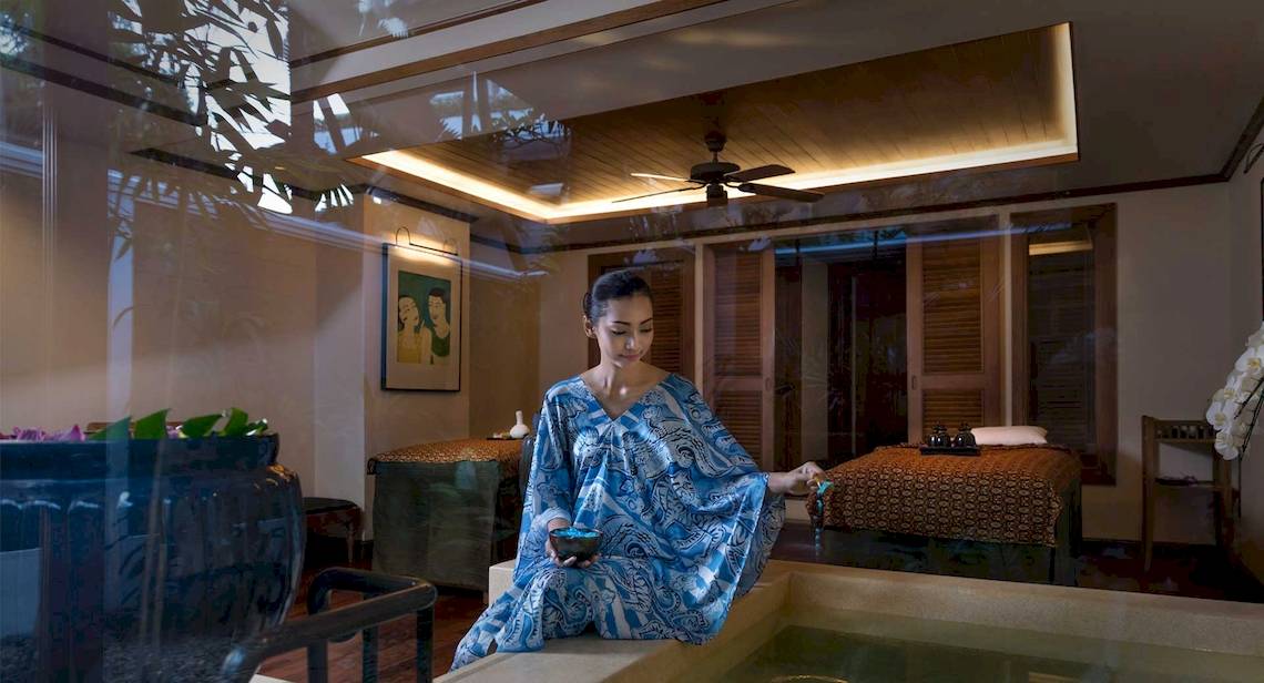 Frau im blauen Kleid am Rande eines Whirlpools im Spa-Bereich des Anantara Riverside Bangkok Resort