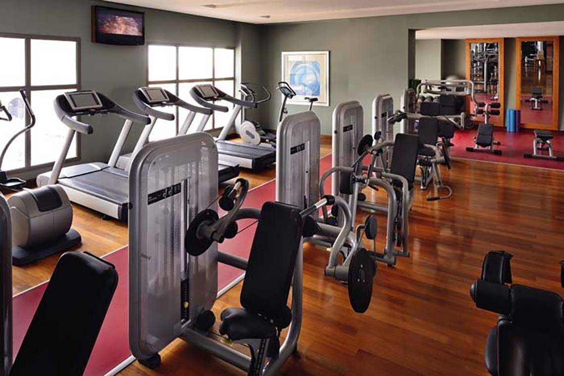 Fitnesscenter im Mövenpick Hotel Jumeirah Beach mit Laufbändern und Kraftgeräten.