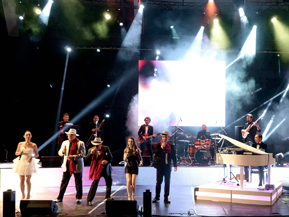 Bühnenshow im Sueno Hotels Deluxe Belek mit Musikern und Sängern unter Scheinwerfern.
