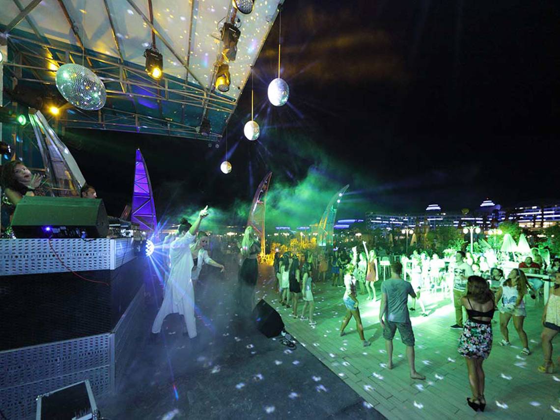 Nachtclub-Veranstaltung im Sueno Hotels Deluxe Belek mit Menschen, die tanzen und Discokugeln