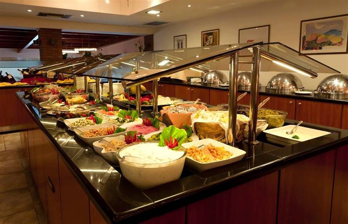 Buffet im Atlantica Marmari Beach Hotel mit verschiedenen Speisen in Schalen und Schüsseln.
