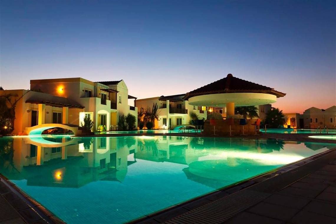 Beleuchteter Pool und Hotelanlage des Atlantica Marmari Beach Hotel bei Nacht