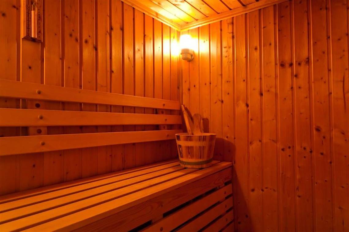 Sauna im Atlantica Marmari Beach Hotel mit hölzernen Wänden und Bänken.