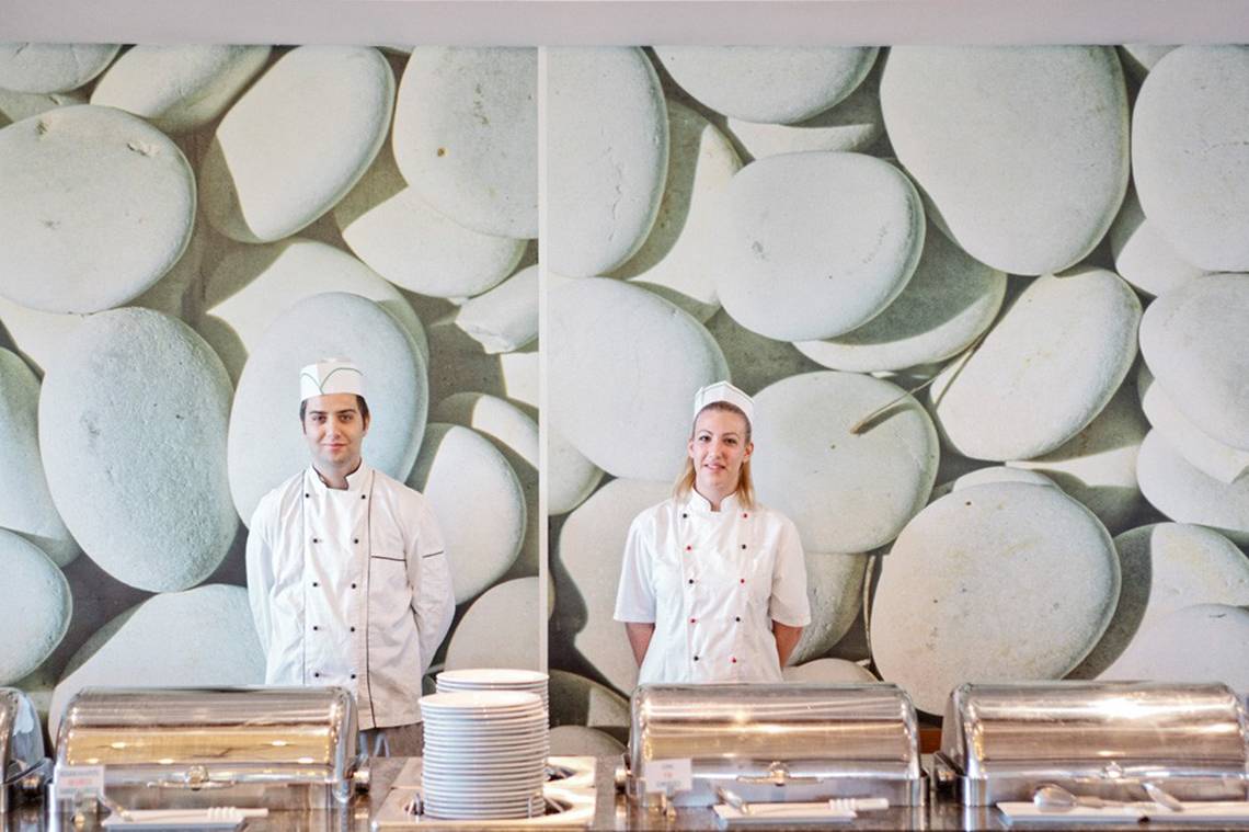 Zwei Köche vor einer Wand mit weißen Kieselsteinen im Kontokali Bay Resort & Spa