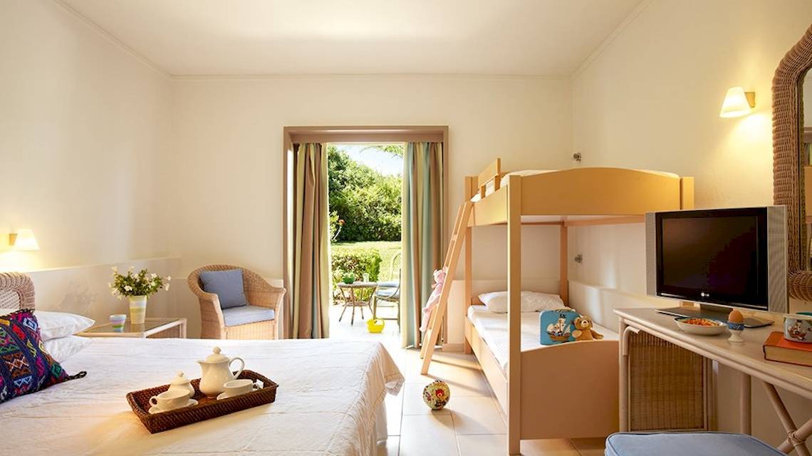 Zimmer im Grecotel Meli Palace mit Doppelbett, Etagenbetten und Balkon.