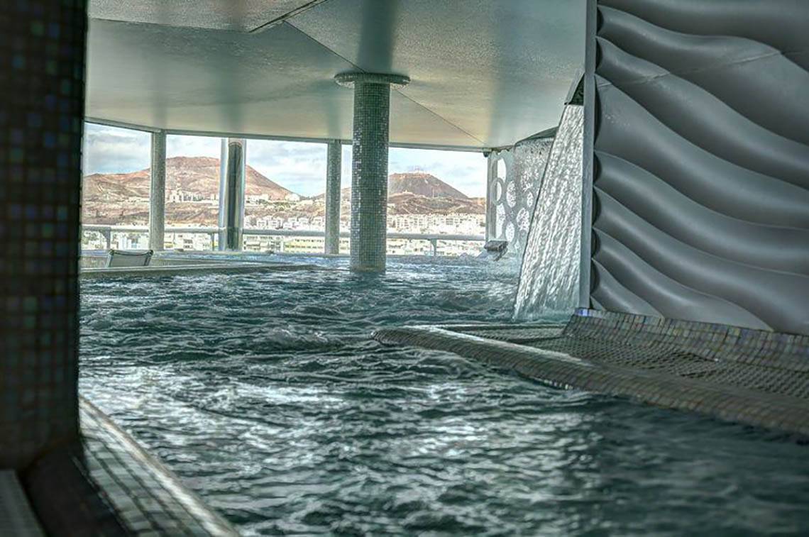 Innenpool des Bull Hotel Reina Isabel & Spa mit Aussicht auf die Stadt und Berge