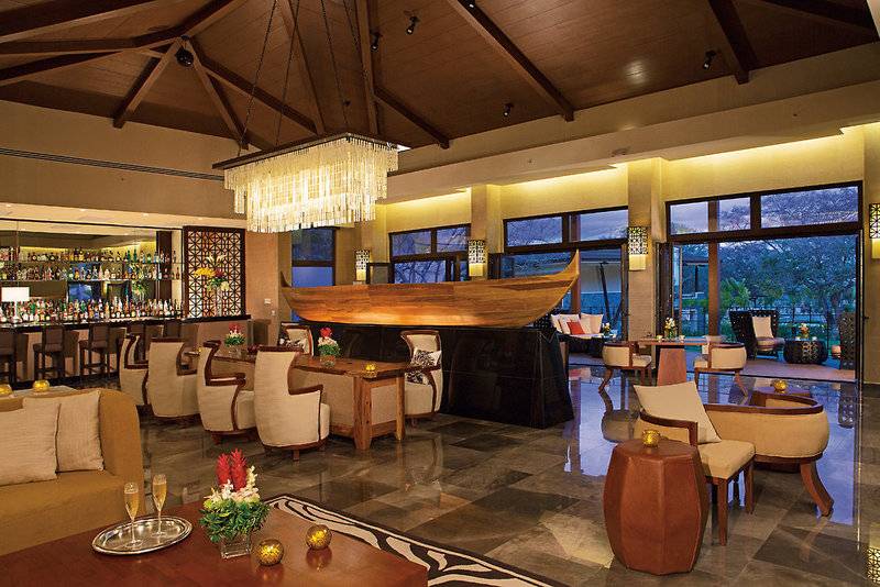 Lobby des Dreams Las Mareas Costa Rica Hotels mit Bar, großen Fenstern und moderner Einrichtung.
