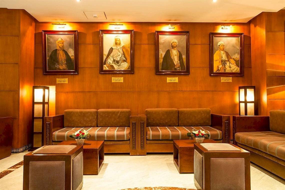 Lobby des Allegro Agadir Hotels mit Porträts und Sofas.