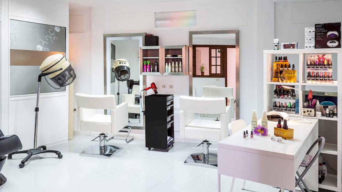 Friseursalon im Hotel Tagoro Family & Fun Costa Adeje mit weißen Stühlen und Geräten.