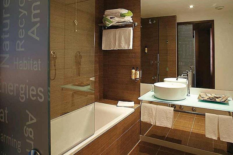 Badezimmer im Neya Lisboa Hotel mit Badewanne, Waschbecken und Handtüchern.