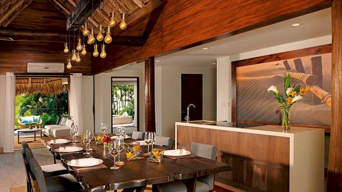 Innenansicht des Esszimmers im Secrets Papagayo Costa Rica Hotel mit langem Esstisch, Stühlen und moderner Einrichtung.