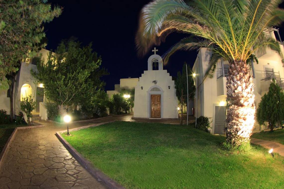 Nachtansicht des Europa Beach Hotel mit Kapelle und gut beleuchtetem Weg.