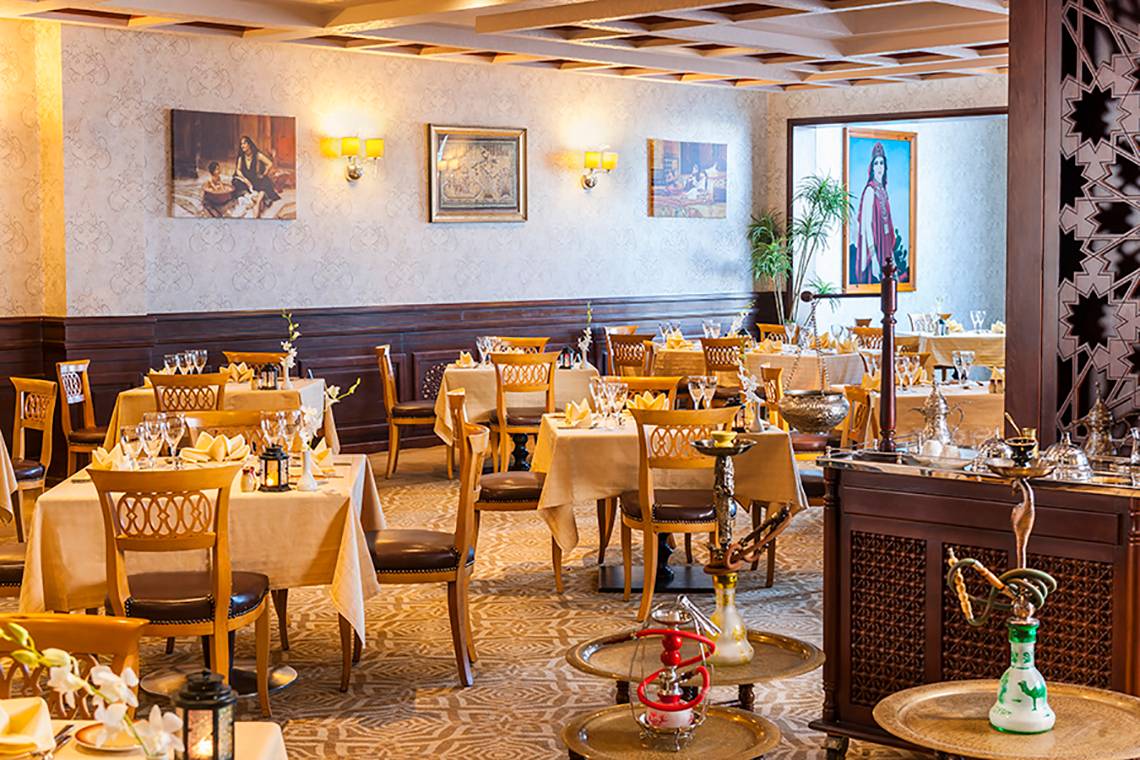 Restaurant im Rixos Sharm El Sheikh mit gedeckten Tischen und traditioneller orientalischer Dekoration.