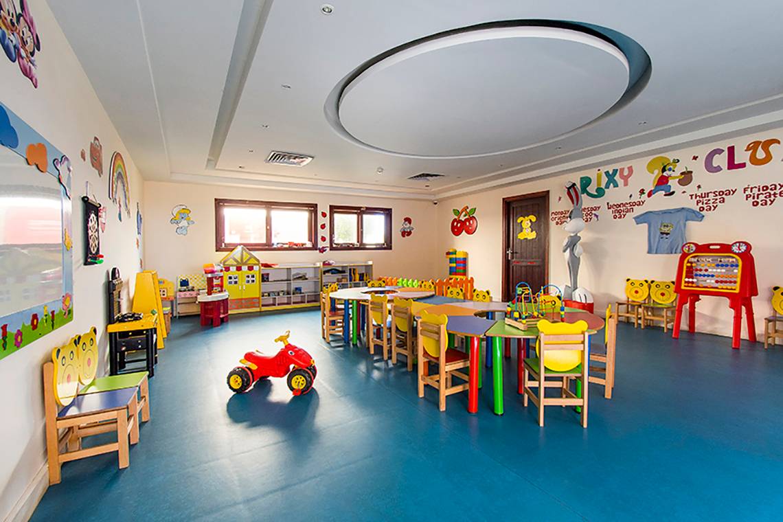 Ein farbenfrohes Kinderzimmer im Rixos Sharm El Sheikh Hotel mit bunten Wänden und Spielzeug.