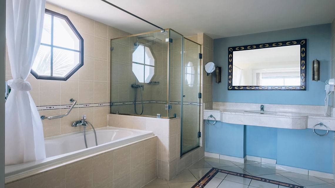 Badezimmer im Iberostar Laguna Azul Hotel mit Badewanne, Dusche und Spiegel.