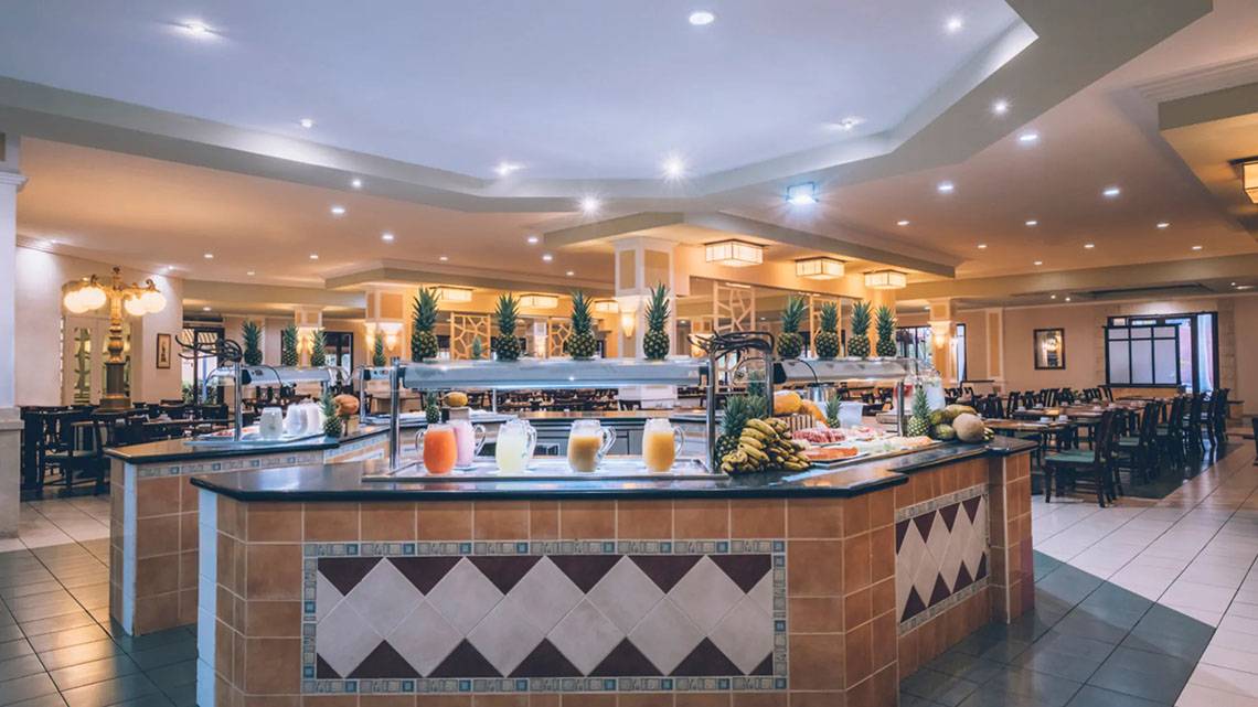 Buffet-Tisch im Iberostar Laguna Azul Hotel mit verschiedenen Früchten und Getränken.
