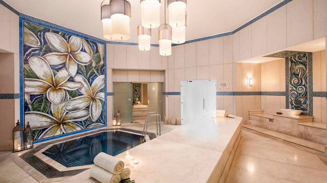 Innenbereich des Spas im Sugar Beach Mauritius mit einem Whirlpool, Marmorboden und dekorativen Wandfliesen.