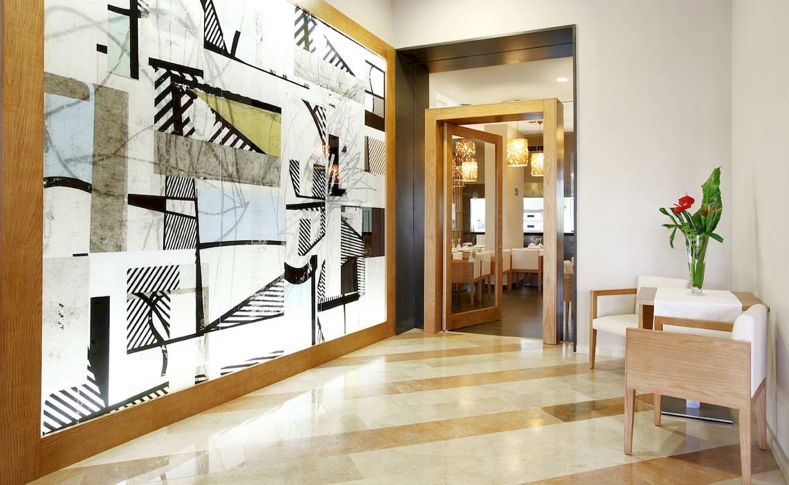 Innenbereich des H10 Las Palmeras Hotels mit moderner Wandgestaltung und Tisch